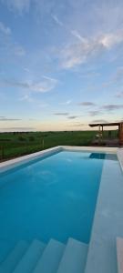 ein großer blauer Swimmingpool mit einem Pavillon in der Unterkunft Monte do Arneiro in Sousel