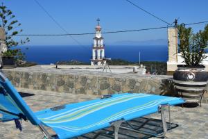 a blue lounge chair with a lighthouse in the background at Despina in Kritinía