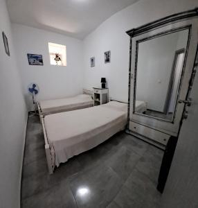 a bedroom with two beds and a large mirror at Despina in Kritinía