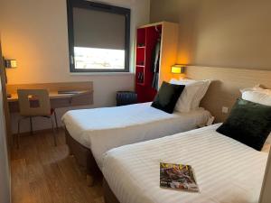 a hotel room with two beds and a desk at Oneloft Hotel in Obernai