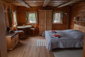 a bedroom with two beds and a table and two windows at Ferienhaus Sonne in Jiříkov
