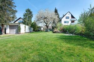 a yard with a white house and trees at Traumhaftes Wohnen beim Badesee in Erlangen