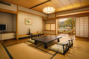 a living room with a table and chairs and a television at 碧翠御苑 ゲストハウス風月庵 in Kyotango