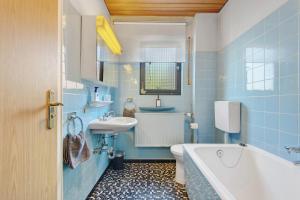 a blue bathroom with a tub and a sink at Traumhaftes Wohnen beim Badesee in Erlangen +31 photos