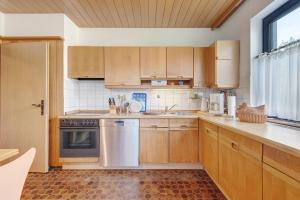 a kitchen with wooden cabinets and stainless steel appliances at Traumhaftes Wohnen beim Badesee in Erlangen