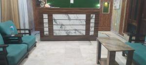 a lobby with two chairs and a table and a door at Hotel Paradise in Chandīgarh