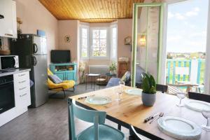 a kitchen and dining room with a table and chairs at Djiiméé, Piscine & vue apaisante sur Golf, 5 pers in Talmont