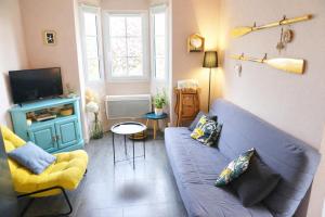 a living room with a blue couch and a tv at Djiiméé, Piscine & vue apaisante sur Golf, 5 pers in Talmont
