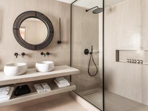 a bathroom with two sinks and a shower at EvMariA suites in Fira