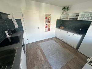 a kitchen with white cabinets and green tile at Hostel by BookieBooking in Wiesbaden +92 photos