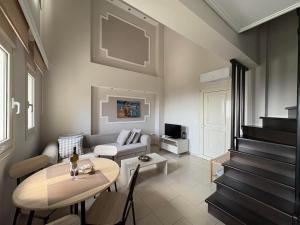a living room with a table and a couch at Maisonettes Athina in Chrysi Ammoudia
