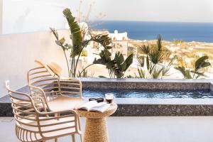 a patio with two chairs and a swimming pool at EvMariA suites in Fira