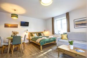 a bedroom with a bed and a couch and a table at Apartmány Lipno-Hory in Horní Planá