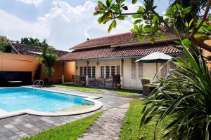 a swimming pool in front of a house at Villa Pondok Terra in Yogyakarta