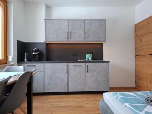 a kitchen with stainless steel cabinets and a table at FEWO Erika in Presseggen +24 photos