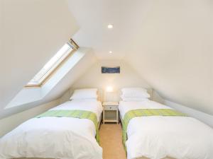 two beds in a attic room with a window at 6 Bed in Strathcarron oc-ca343 in Applecross