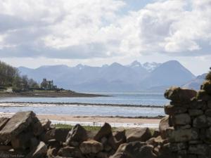 a beach with rocks and mountains in the background at 6 Bed in Strathcarron oc-ca343 in Applecross
