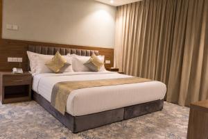 ein Schlafzimmer mit einem großen Bett und einem Nachttisch in der Unterkunft WS Hotel in Tabuk + 35 Fotos