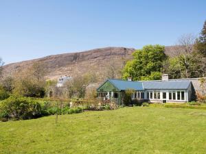 a house in a field with a hill in the background at 2 Bed in Applecross oc-ca422 in Applecross