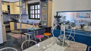 a kitchen with blue cabinets and a table and chairs at Βίλα Πασιθέα in Kiveri