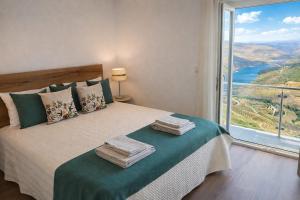 a bedroom with a bed with a large window at Panorama Douro House in Armamar +10 photos