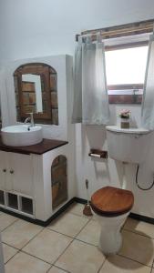 a bathroom with a sink and a toilet and a mirror at Tofo Beach Gardens in Inhambane +37 photos