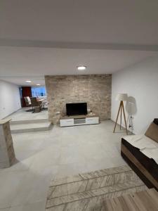 a large living room with a fireplace and a tv at Apartmani ,,Merlin,, in Utjeha