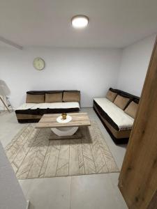 a living room with two beds and a coffee table at Apartmani ,,Merlin,, in Utjeha
