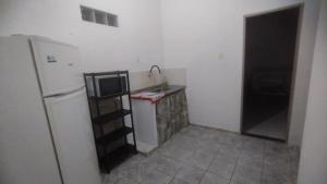 a kitchen with a white refrigerator and a sink at Casa Próxima ao Centro in Itajubá