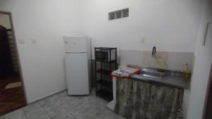 a kitchen with a white refrigerator and a microwave at Casa Próxima ao Centro in Itajubá