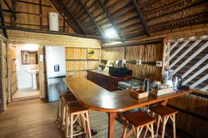 a kitchen with a large wooden table in a room at Tofo Beach Gardens in Inhambane