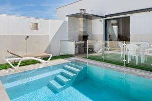 a swimming pool in the backyard of a house at Casas Las Arenas 2 in Conil de la Frontera