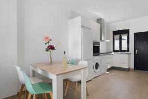 a kitchen with a table and chairs and a kitchen with white cabinets at Casas Las Arenas 2 in Conil de la Frontera