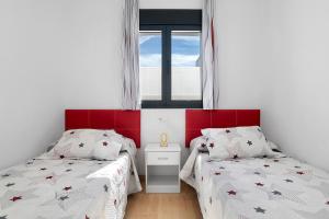 a bedroom with two beds and a window at Casas Las Arenas 2 in Conil de la Frontera +17 photos