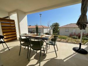 a dining table and chairs on a patio at Magnifique T3 full équipé, 100m de la plage et piscine N60 in Linguizzetta