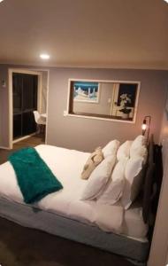 a bedroom with a large bed with white pillows at Tiki Hut in Tauranga