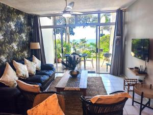 a living room with a couch and a table at OceanFront- Whale Watch- On Beach- Stunning in Umdloti