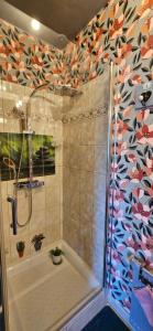 a bathroom with a shower with a shower curtain at Chambres d'hôtes Les Chênes in Acigné