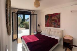 a bedroom with a bed and a large window at La Maison du Bonheur in Saint-Raphaël +35 photos