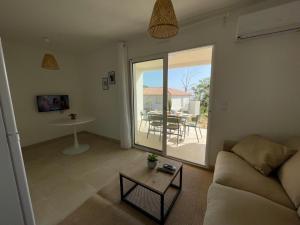 a living room with a couch and a table at Magnifique T3 full équipé, 100m de la plage et piscine N60 in Linguizzetta