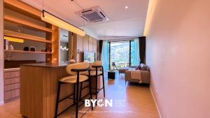 a kitchen with a bar and a living room at Enclave Nature Suites Bukit Tinggi by BYON in Bentong