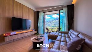 a living room with a couch and a flat screen tv at Enclave Nature Suites Bukit Tinggi by BYON in Bentong