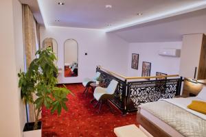a bedroom with a bed and a desk and a plant at Royal Crown Apartments in Subotica
