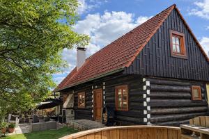 ein Holzhaus mit einem braunen Dach in der Unterkunft Do roubenky in Kamenný Malíkov