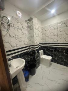 a bathroom with a sink and a toilet at Hotel Tu Casa in Kolkata