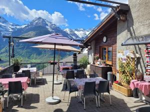 a patio with tables and chairs with mountains in the background at Osteria Anzonico in Anzonico +51 photos
