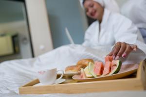 a woman serving a tray of food with a plate of fruit at Le felix in Antananarivo +22 photos