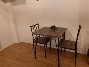 a wooden table with two chairs and a plant on it at BEAVER HOTEL and RESIDENCES in Cebu City