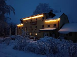 a building with lights on it in the snow at Chata Florian in Adolfov