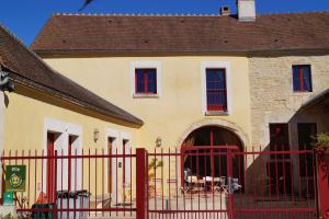 a yellow house with a red fence in front of it at Le P'tit Louis in Saint-Cyr-les-Colons
